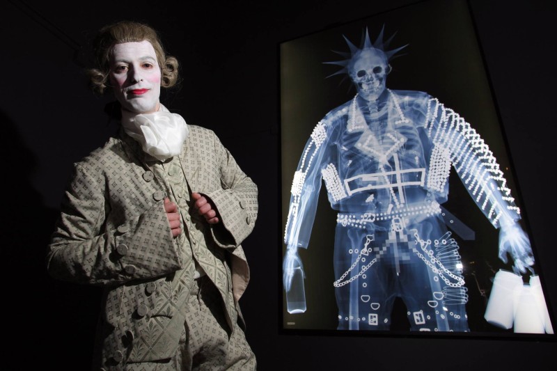 'Shaping The Body' Exhibition at The York Castle Museum. A major new exhibition exploring the way fashion, food and fitness have shaped the body over the last 400 years, opens at The York Castle Museum in York, on Friday 25th March 2016. The exhibition features an iron corset, crotchless pantaloons from the time of Jane Austen, bum rolls and a killer dress (made from arsenic), and a diminutive dress worn by Queen Victoria, and traces the changing fashion trends and body shapes from the waist clinching Tudor corset through to Punk Rock and to the extremes of transgender men and women to those with piercings and tattoos. The Exhibition 'Shaping the Body' opens to the public this Friday 25th March 2016. Seen here: Lee Clark from The York Museums Trust dressed in a Georgian Macaroni Suit, in the shadow of an X-ray of a Punk with all his piercings..!!!