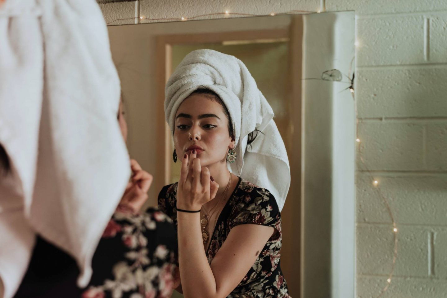 A woman with a towel looking in the mirror